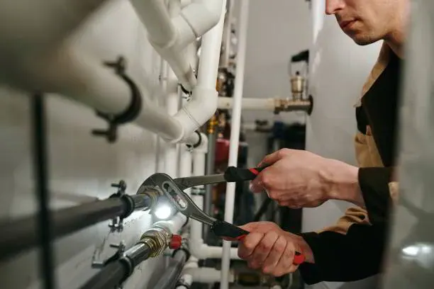 Plumber tightening a fitting on commercial water lines