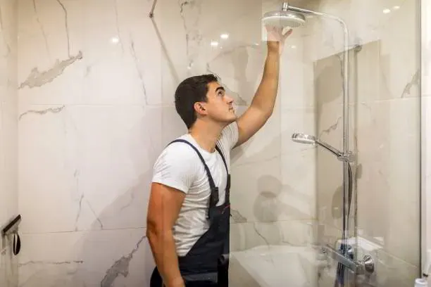 Plumber replacing a shower valve cartridge as part of shower and tub plumbing services